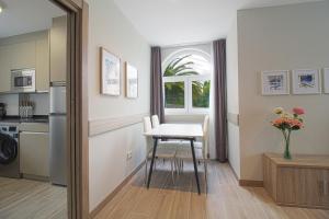 eine Küche und ein Esszimmer mit einem Tisch und einem Fenster in der Unterkunft Apartamentos Turísticos La Pontificia in Comillas