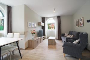 een woonkamer met een bank en een tv bij Apartamentos Turísticos La Pontificia in Comillas