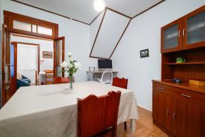 een eettafel met een vaas met bloemen erop bij Casa da Avó in Vila Franca do Campo