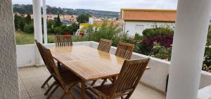 a wooden table and chairs on a balcony at Villa Jopati in Olho Marinho