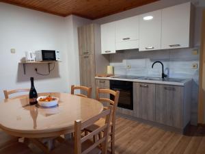 eine Küche mit einem Tisch und einer Flasche Wein in der Unterkunft Apartma Melita in Rovte
