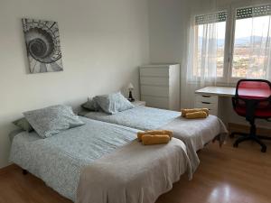 2 camas en un dormitorio con escritorio y silla en Apartamento de 3 habitaciones en GIRONELLA - ALBERGA, en Gironella