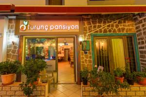 ein Eingang zu einem Speiserestaurant mit Topfpflanzen im Außenbereich in der Unterkunft Turunç Pansiyon in Bodrum City
