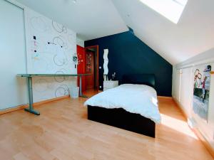a bedroom with a bed and a blue wall at Jean Monnet - Séjour à Auxerre in Saint-Georges-sur-Baulche