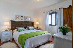 a bedroom with a large bed with a green blanket at Casa Vereda del Risco in Guinate