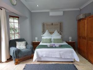 センチュリオンにあるLily's Innの大きなベッドと椅子のある寝室