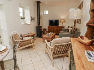 a living room filled with furniture and a tv at Watermill Cottage in Chathill
