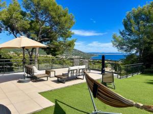 una hamaca en un patio con vistas al océano en Résidences des Peyrons vue exceptionnelle mer et sur les Iles d'Or, en Carqueiranne