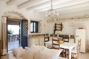 eine Küche und ein Wohnzimmer mit einem Tisch und einer Couch in der Unterkunft Casa Degli Aromi in Noto