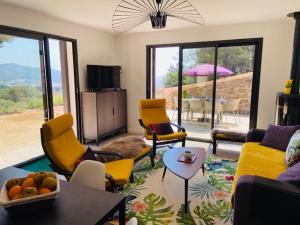 Una sala de estar con sillas amarillas y una mesa. en Résidences des Peyrons vue exceptionnelle mer et sur les Iles d'Or, en Carqueiranne