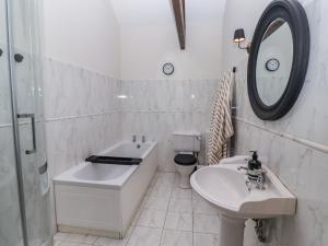 a bathroom with a sink and a tub and a toilet at Watermill Cottage in Chathill +34 photos