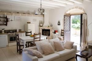 ein Wohnzimmer mit einer weißen Couch und einer Küche in der Unterkunft Casa Degli Aromi in Noto + 42 Fotos