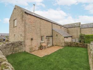 an exterior view of a brick building with a yard at Watermill Cottage in Chathill