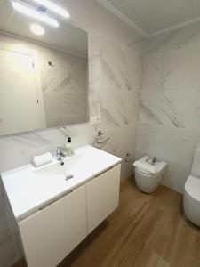 un bagno bianco con lavandino e WC di Marynton Boutique a Benicarló Altre 53 foto