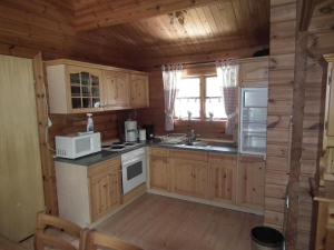 een keuken met houten kasten en een witte magnetron bij Wunderschönes Ferienhaus Am Waldrand in Bad Arolsen +32 foto's