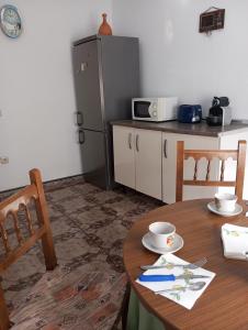 a kitchen with a table and a refrigerator at El descanso soberano in Ossa de Montiel +4 photos