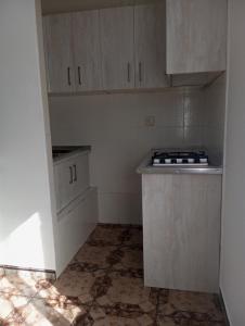 a small kitchen with white cabinets and a stove at El descanso soberano in Ossa de Montiel