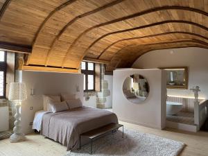 a bedroom with a bed and a mirror and a sink at Manoir de Kerenneur in Plourin