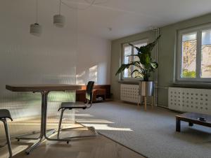 una sala de estar con una mesa y una silla en Rakietników vintage condo, en Varsovia
