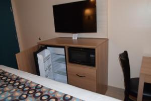 a tv on top of a wooden cabinet with a dresser at Seahorse Inn in Wildwood