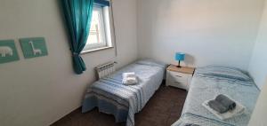 a bedroom with two twin beds and a window at Villa Jopati in Olho Marinho +25 photos