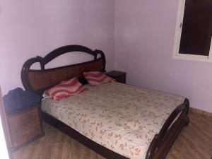 a bedroom with a bed with two pink pillows on it at Villa dar deyafa jamaat fedalat in Sidi Moussa Ben Ali