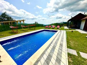 a swimming pool in a yard with chairs at Vila David 2 Comarnic in Comarnic