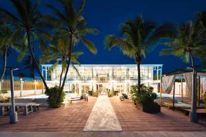 a building with palm trees in front of it at Oceanfront Colonial Beach Villa 6Bedrooms, Sleeps 28 in Hua Hin