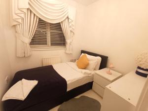 a small bedroom with a bed and a window at Luxury 3 Bedroom House with Parking in Northfleet