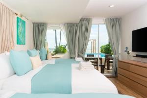 a bedroom with two beds and a flat screen tv at Oceanfront Colonial Beach Villa 6Bedrooms, Sleeps 28 in Hua Hin