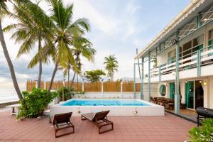 a house with a swimming pool and palm trees at Oceanfront Colonial Beach Villa 6Bedrooms, Sleeps 28 in Hua Hin