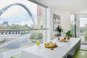 a white kitchen with a large window with an archway at Dunham Halls Manchester Met in Manchester