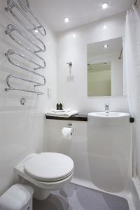 a white bathroom with a toilet and a sink at Dunham Halls Manchester Met in Manchester