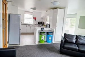a kitchen with a refrigerator and a couch in a room at Dunham Halls Manchester Met in Manchester