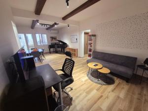 een woonkamer met een bank, een tafel en een piano bij The Music Box in Skopje +11 foto's