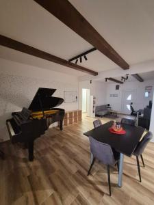 een woonkamer met een piano en een tafel bij The Music Box in Skopje