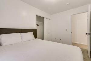 Un dormitorio con una gran cama blanca con almohadas blancas. en 3 Mi to Dtwn Worcester! Spacious 2-Story Townhome!, en Worcester