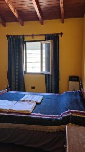 a bed in a room with a window with towels on it at Humadepto in Humahuaca