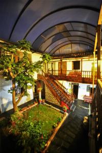 Ático de un edificio con un árbol y escaleras en Hostal el Conquistador, en Cusco
