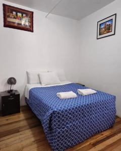 Un dormitorio con una cama con dos toallas encima. en Hostal el Conquistador, en Cusco