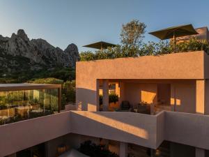 a view of a building with mountains in the background at La Suera San Pantaleo in San Pantaleo