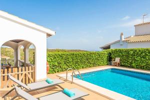 a villa with a swimming pool and a house at Villa Cala Llonga in Cala Llonga