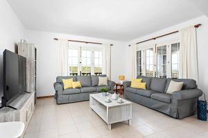 a living room with two couches and a tv at Villa Cala Llonga in Cala Llonga