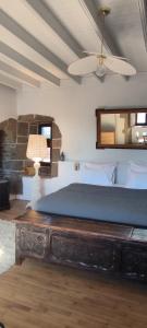 a bedroom with a large bed with a wooden table at Manoir de Kerenneur in Plourin