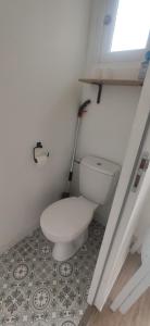 a white toilet in a bathroom with a window at Jolie maison à 700 m de la mer in Piriac-sur-Mer +2 photos