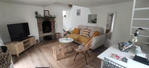 a living room with a couch and a tv at Jolie maison à 700 m de la mer in Piriac-sur-Mer
