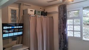 ショルシェールにあるGrand F2, spa, jardin, parkingのテレビとカーテン付きの窓が備わる客室です。