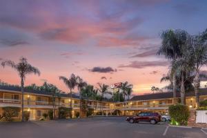 a hotel with a car parked in a parking lot at Best Western Plus Carriage Inn in Sherman Oaks