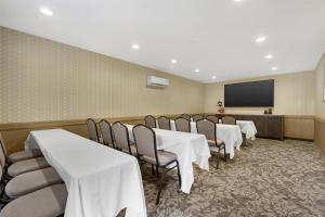 a conference room with tables and chairs and a screen at Best Western Plus Carriage Inn in Sherman Oaks +42 photos