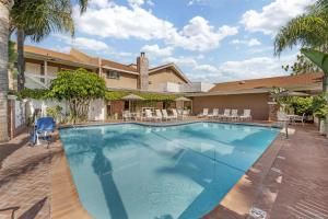 a large swimming pool in front of a house at Best Western Plus Carriage Inn in Sherman Oaks